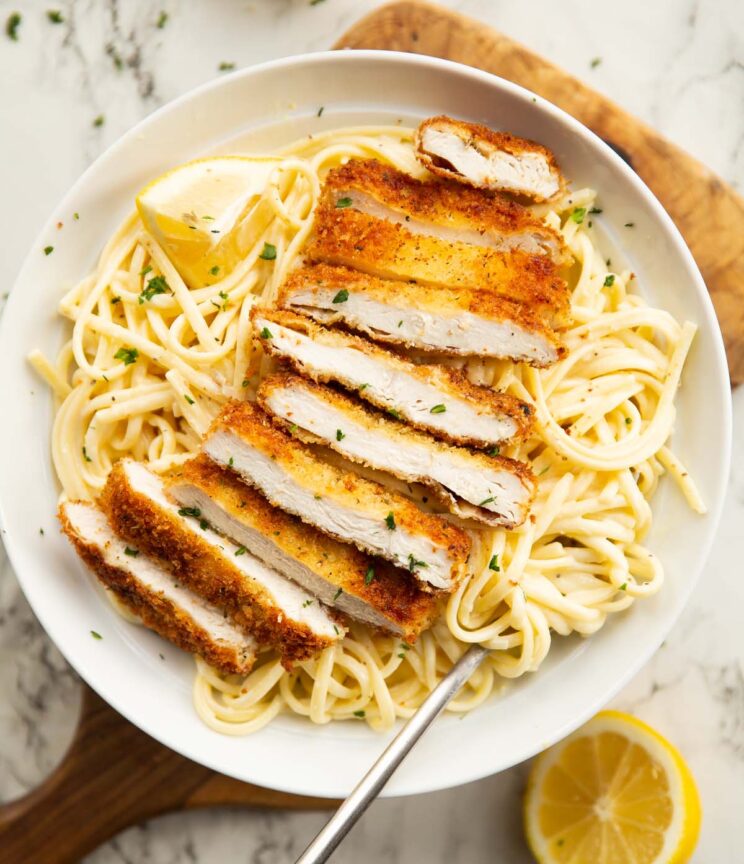 overhead shot of lemon chicken pasta served in large white bowl with silver fork