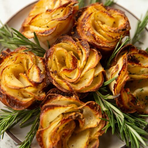 potato roses on small white plate with rosemary
