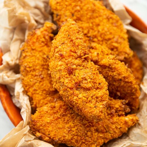 close up shot of Doritos chicken tenders in bowl with brown parchment paper