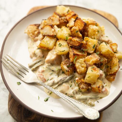 potato chicken tarragon bake on small white plate with silver fork