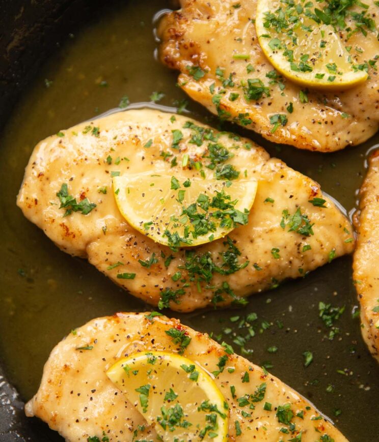 lemon honey chicken in large pan garnished with lemon wedges and parsley